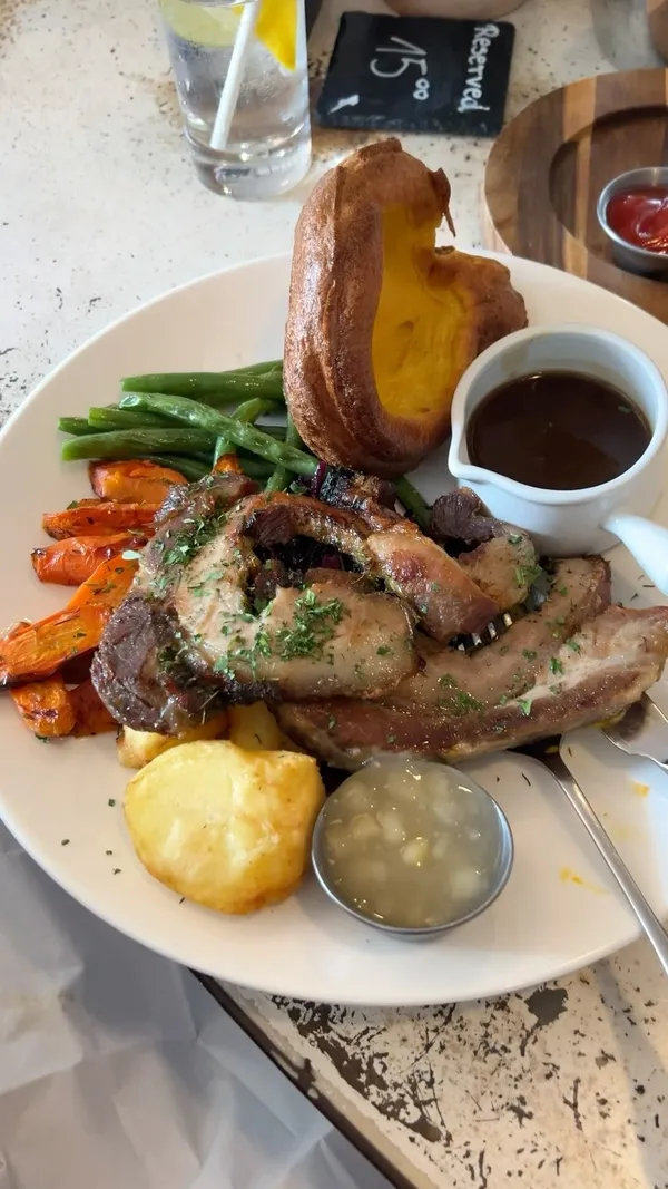 The video showcases a couple enjoying a meal at The Address restaurant in Canary Wharf.  The food and drink items featured include Eggs Royale, roasted pork belly, various crostini, crispy squid, a Caesar salad, skin-on fries, and mango & coconut margaritas. The presentation emphasizes the visual appeal of each dish with close-up shots and overhead shots, highlighting the colors and textures. No specific dietary information is explicitly mentioned.
