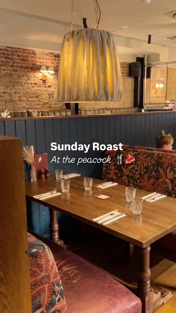 The video showcases The Peacock, a cozy pub in Islington, London, promoting their Sunday Roast. It features various roast dinner options, including beef, pork, and lamb, along with Yorkshire puddings, roast potatoes, vegetables, and gravy.  The video highlights the pub's ambiance and the appealing presentation of the food. 