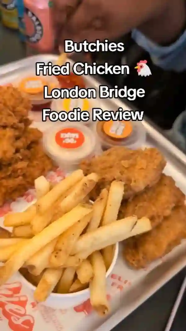 This video showcases a visit to Butchies Fried Chicken in London Bridge.  The content creators sample a variety of items, including burgers, chicken wings, chicken strips, halloumi fries, and chips, alongside Dalston drinks. The food is presented attractively on branded trays. The main focus is a tasting and review of the different menu items, particularly emphasizing the chicken strips and chili honey sauce.