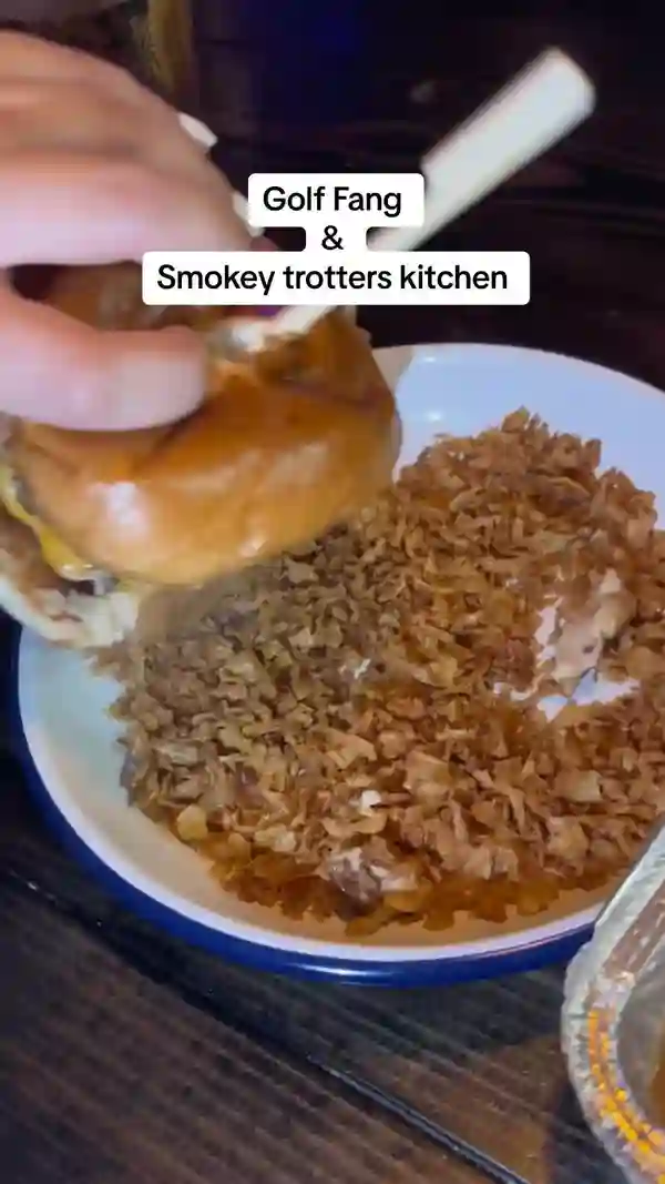 This video showcases Golf Fang, a crazy golf venue in Glasgow, UK. It highlights their "Sugar Daddy" package which includes a round of golf, an alcoholic beverage, and food from Smokey Trotters Kitchen. The food featured includes a cheeseburger ("Dirty Dipper") with haggis, peppercorn sauce, and crispy onions, along with Cajun garlic butter and garlic mayo chicken tenders and fries. The video emphasizes the venue's pop culture references and vibrant, colorful decor.