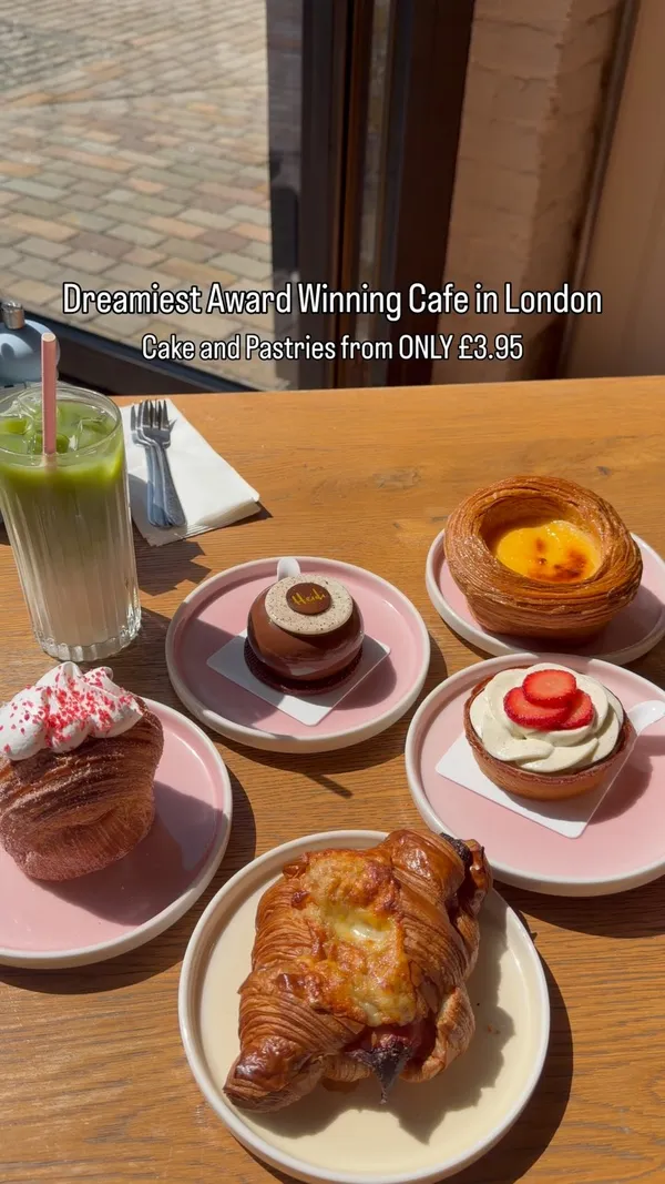 A short, punchy reel showcasing a variety of pastries and cakes at a London cafe. The video focuses on close-up shots of the food being broken open to reveal textures, alongside a quick pan of the display case and the outdoor seating area.