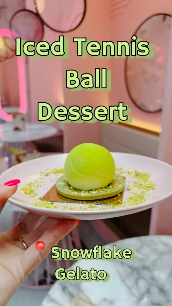 The video showcases Snowflake Gelato, a cafe offering gelato, iced lattes, and desserts.  It features various gelato flavors (including hazelnut, chocolate bounty, pistachio, and strawberry cheesecake), an iced pistachio latte, and a pistachio tennis ball dessert with raspberry filling. The presentation emphasizes clean, modern aesthetics, with pink and white color schemes. Gluten-free options are highlighted, with allergen information available. The main focus is on showcasing the food and drink, creating a visually appealing experience.