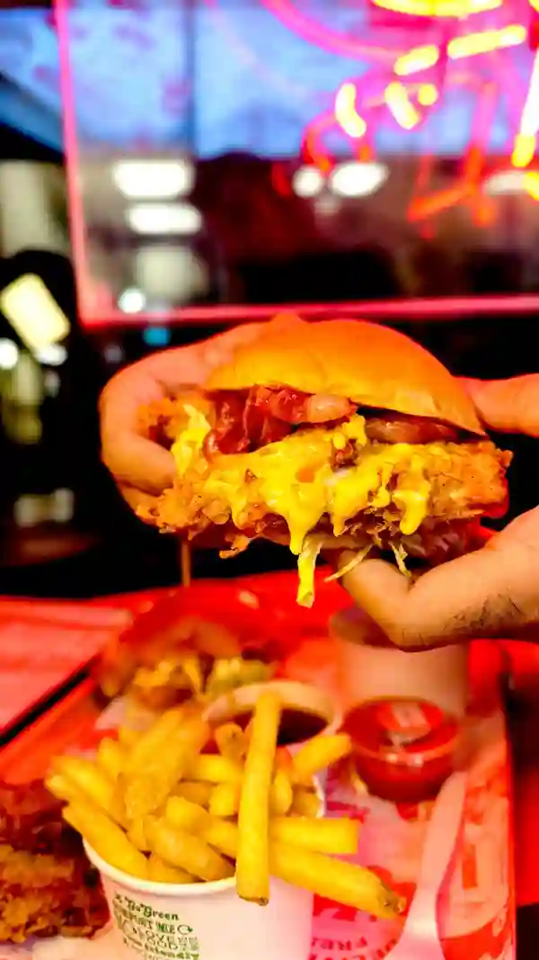 The video showcases a cheesy burger meal from Butchies London. It features a close-up of the burger, which appears to be topped with a generous amount of cheese sauce.  Other items included are fries, mac and cheese, and a dipping sauce. The setting is a casual restaurant, and the video emphasizes the cheesy aspect of the meal. No dietary information is explicitly provided.