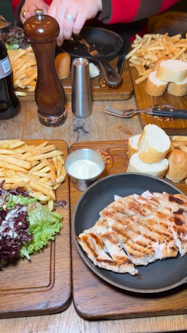 A short, punchy montage showcasing the signature steak and fries offering at Swiss Butter London, featuring close-up shots of sauce pouring, food dipping, and dessert.