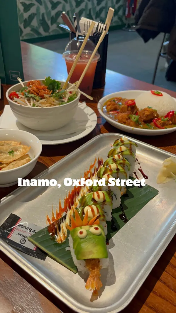 The video showcases a meal at Inamo restaurant in Market Halls, London.  The food includes a dragon roll (sushi), katsu curry with rice, gyoza (dumplings), and a noodle soup. The presentation is visually appealing, with vibrant colors and creative plating, particularly the dragon roll.  No specific dietary information is provided. The video's main focus is showcasing the food and the restaurant's atmosphere.