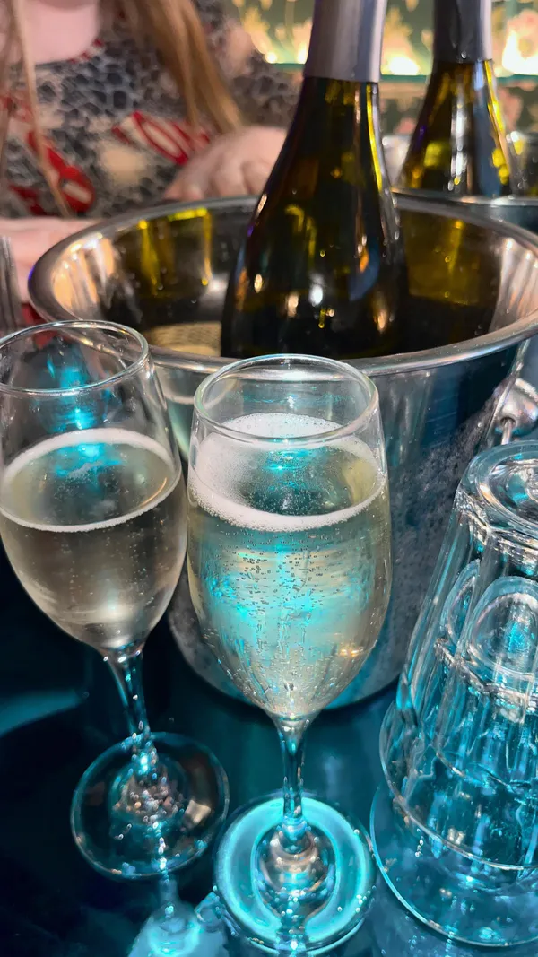 This video showcases a drag brunch event at Blame Gloria, a bar in London. The video features bottomless Prosecco, cocktails (a pink-colored drink is prominently featured), and a burger with fries. The presentation emphasizes fun, vibrant colors, and a lively atmosphere.  No dietary information is explicitly provided. The main focus is on the party atmosphere and the drag queen performance, alongside food and drink consumption.
