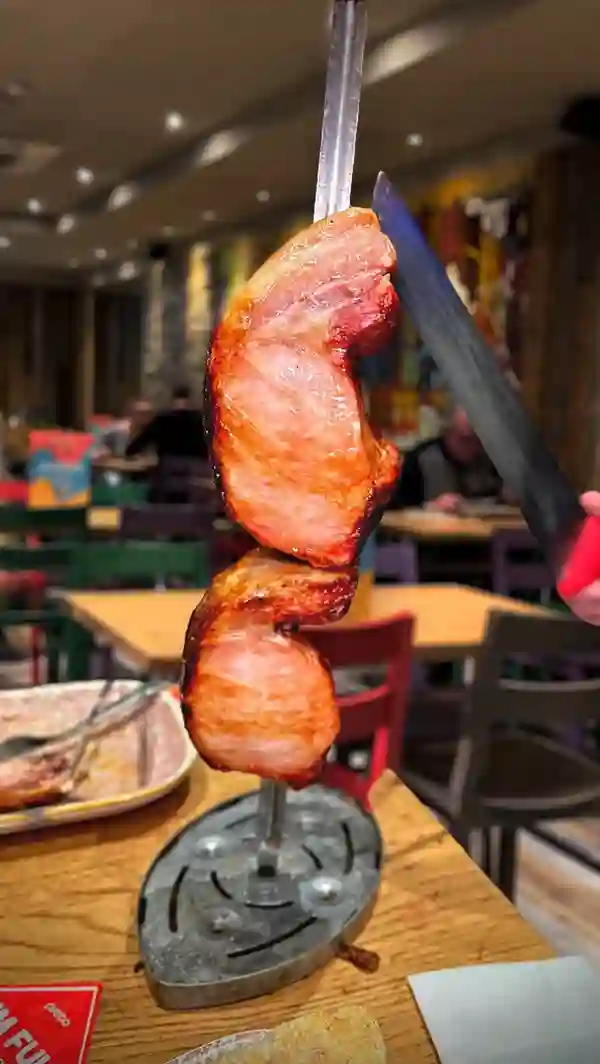 This video showcases Preto Restaurant, a Brazilian Rodizio establishment in Putney, London. The video presents a variety of grilled meats (picanha, sausages), unlimited sides (salad, potatoes, pasta salad, corn), and desserts (flan, cheesecake). The food is presented attractively on plates, highlighting its visual appeal. No dietary information is explicitly mentioned. The main focus is on the all-you-can-eat dining experience.