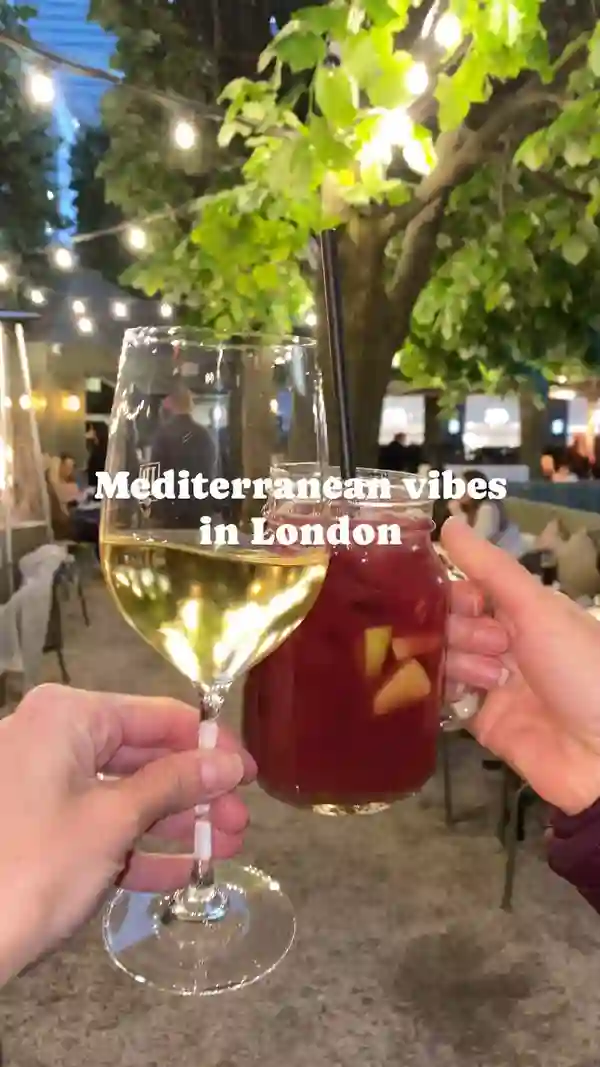 The video showcases La Terraza by Iberica, a restaurant in Cabot Square, London. It features alfresco dining, showcasing various Spanish tapas, including boccadilos (sandwiches) and cured meats like jamon.  Classic Spanish drinks like sangria and sparkling wine are also highlighted. The presentation emphasizes the vibrant atmosphere and appealing food and drink.