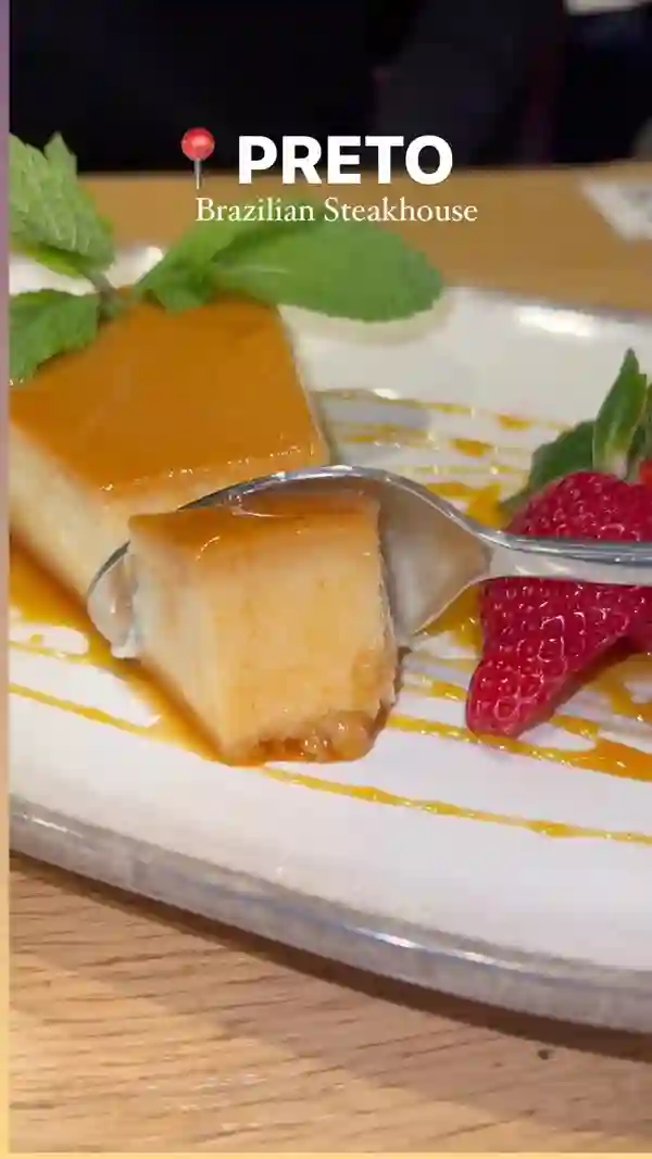 This video showcases Preto Brazilian Steakhouse, highlighting its unlimited spit-roasted meats, various side dishes (including black beans and rice), and desserts (such as flan and passion fruit mousse). The setting is the restaurant itself, with shots of the food, the interior, and customers enjoying the meal.  The video primarily focuses on the variety and abundance of food offered.