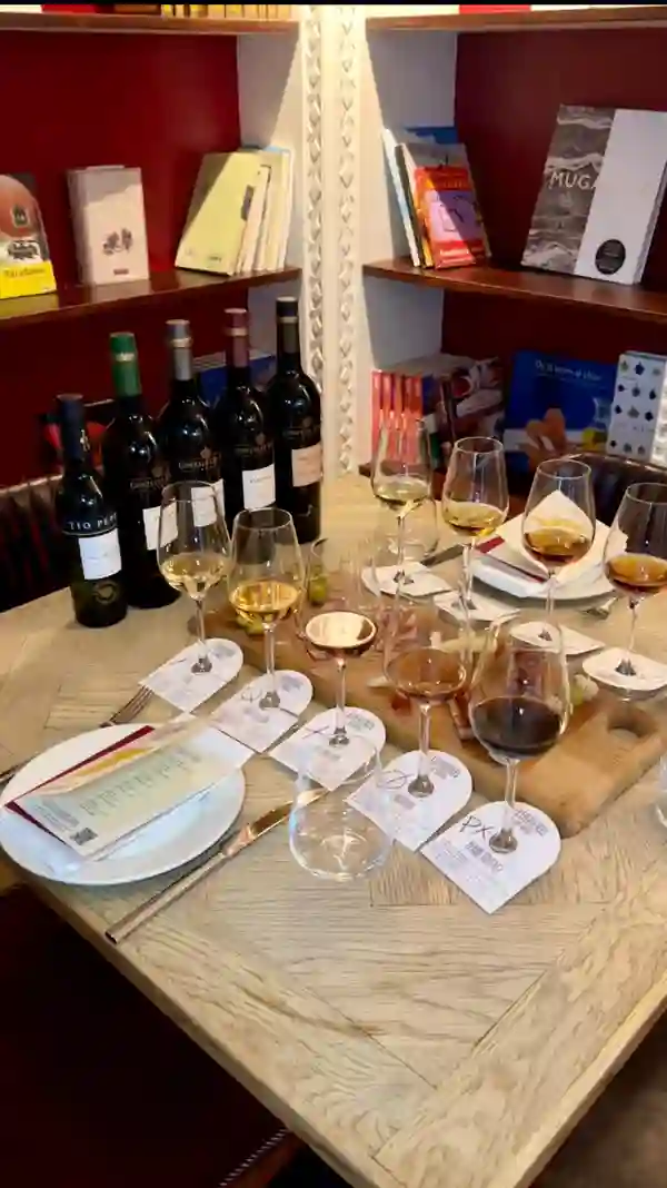 This video showcases a sherry tasting experience at the Iberica Restaurant.  The setting is the restaurant's interior, featuring a tasting table with five varieties of sherry, paired with tapas such as cured meats, cheeses, and olives.  The presentation is elegant and well-lit, highlighting the food and drink.  No dietary information is explicitly given. The main focus is on the sherry tasting, interspersed with shots of the restaurant and the influencer's reactions.