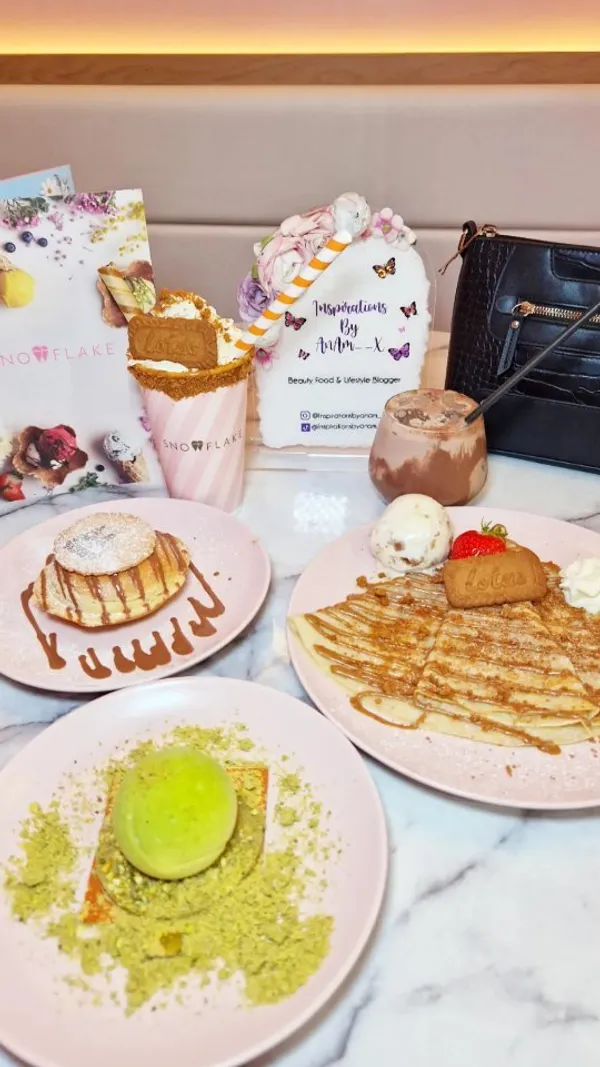 The video showcases Snowflake Gelato, a cafe in London's Soho.  It features various desserts and drinks, including an Oreo crumble doughnut, Lotus Biscoff crepe, a limited-edition pistachio tennis ball dessert (Wimbledon themed), a Lotus Biscoff sundae, and an iced chocolate. The presentation focuses on visually appealing arrangements with pastel-colored plates and a pink theme.  No specific dietary information is provided. The main focus is a meal showcase.