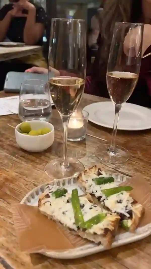 The video showcases a wine tasting event at Iberica Restaurants in London. It features various Spanish wines, including sparkling and rosé, paired with tapas-style dishes like asparagus toast and croquetas. The restaurant's ambiance is also highlighted, showing both the dining area and the bar. The presentation focuses on the food and drinks, with some shots of the people enjoying the event. No dietary information is explicitly mentioned.