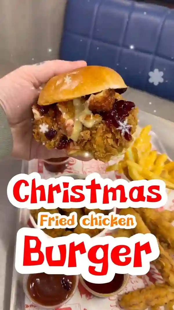 The video showcases a Christmas-themed fried chicken burger from Butchies in London. It highlights the burger's components: buttermilk chicken tenders, deep-fried Camembert, cranberry sauce, and chili honey.  The setting is primarily within the restaurant, with brief exterior shots. The food is presented in close-up shots emphasizing the textures and colors.