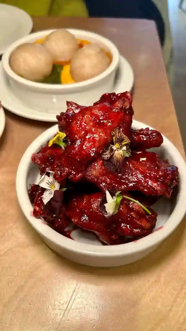 This video showcases a meal at Chuku's, a Nigerian tapas restaurant in Tottenham, London.  The video features various dishes, including sweet okra, jollof rice, dodo, adalu, egusi bowl, zobo wings, banga chicken, honey suya prawns, and cheesecake. The food is presented attractively, with close-up shots highlighting textures and colors. The video focuses on a food review, showing the influencer enjoying the meal. No specific dietary information is provided.