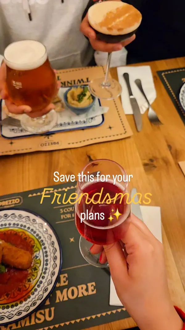 The video promotes the festive menu at Prezzo Italian restaurant. It features a group of friends enjoying a 'Friendsmas' meal, starting with a toast of various drinks. The content showcases the Christmas menu and specific dishes, including starters like mozzarella sticks and bruschetta, mains like a veggie pizza and butternut squash spaghetti, and desserts such as chocolate fudge cake and cheesecake. The video is set to upbeat Christmas music and highlights the restaurant's cozy, festive ambiance and decor.