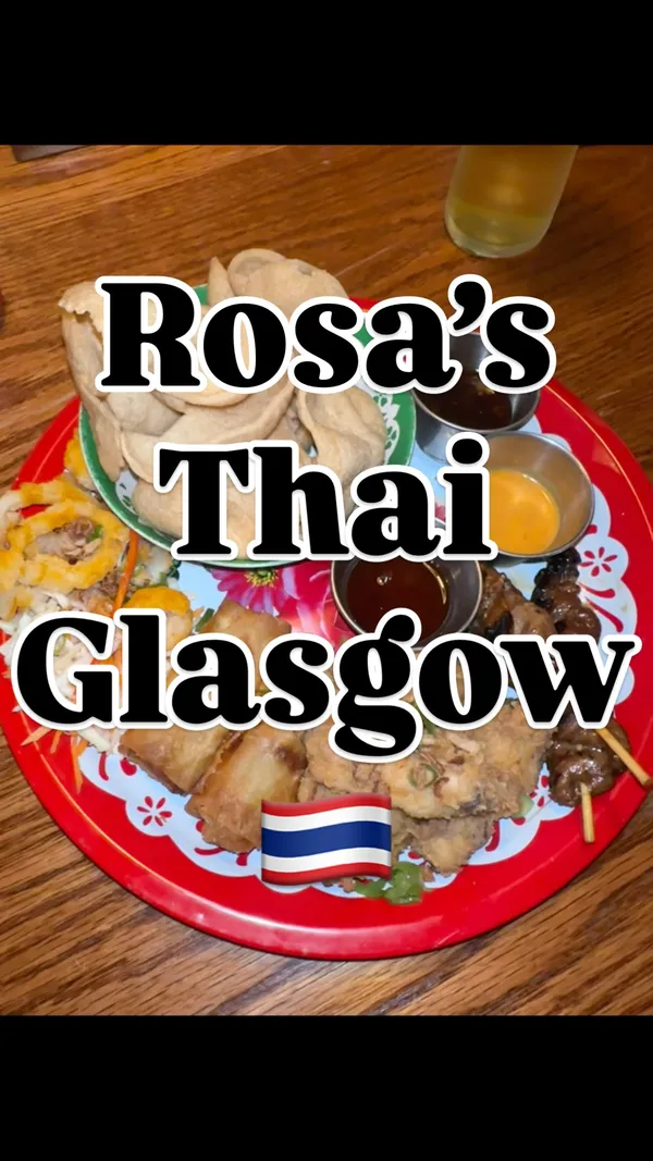 A video review of Rosa's Thai restaurant in Glasgow. It begins with an exterior shot, moves inside to show the decor and menu, and then showcases several dishes including a classic sharing platter (with calamari, spring rolls, chicken wings, pork skewers), chicken pad thai, and a sea bass red curry with sticky rice.