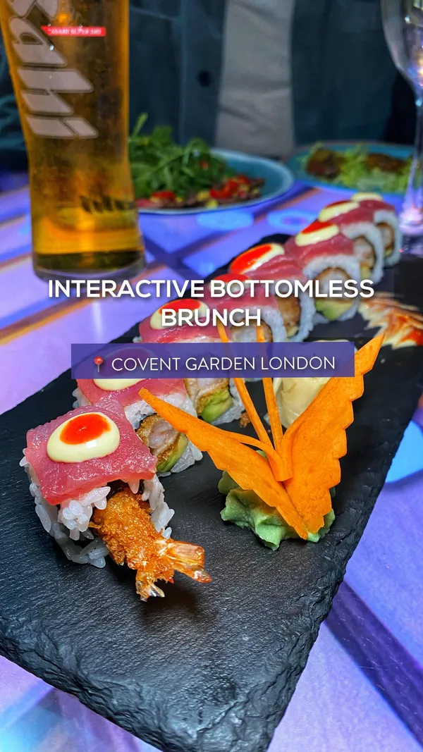 The video showcases Inamo restaurant's bottomless brunch in Covent Garden, London. It features a variety of Asian tapas and creative sushi, including Yuzu Pork Belly, Teriyaki Beef Wraps, Chicken Karaage Katsu, and various sushi rolls. The food is presented attractively on slate plates, with some dishes artfully arranged. The restaurant uses interactive tables where customers can order food and play games. The video emphasizes the bottomless nature of the brunch (Asian tapas, sushi, and drinks) and its interactive dining experience. No specific dietary information is provided.