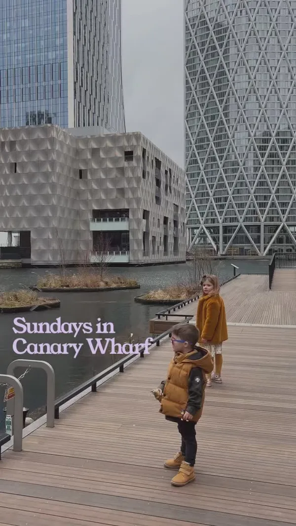 The video showcases a family outing to Canary Wharf, London, focusing on their Sunday lunch at No.35 Mackenzie Walk. It begins with shots of the modern architecture and waterways of Canary Wharf, followed by the family arriving at the restaurant. The video features shots of the restaurant's interior, menus, and the food they ordered, including roasted aubergine hummus, hot chicken tenders, kids' roast dinners (with Yorkshire pudding, roast potatoes, and vegetables), and a dessert. The presentation of the food is highlighted, with close-ups of the dishes. The main focus is on the family enjoying their meal and the child-friendly atmosphere of the restaurant.