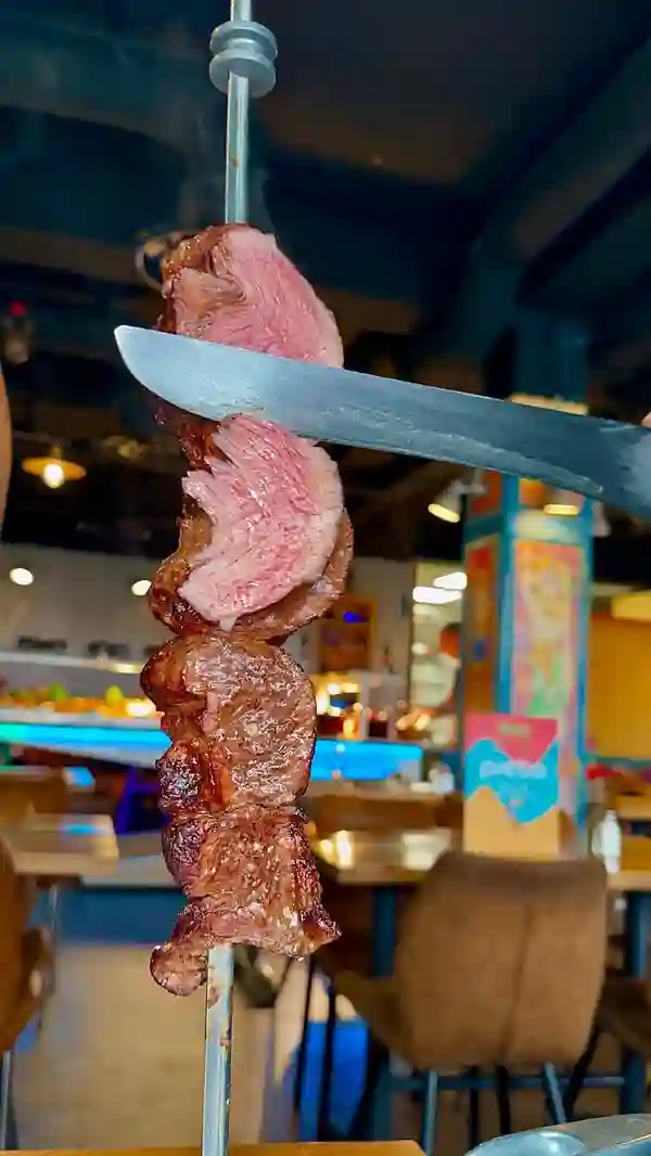 This video showcases Preto Brazilian restaurant in London, offering an unlimited lunch buffet for £16.95 (Mon-Fri, 12-3pm) and dinner for £26.95 (Mon-Sun, 3:30pm-closing).  The buffet includes various salads and hot dishes, while a selection of grilled meats (pork, beef, lamb, chicken) is served tableside.  Garlic bread and cocktails are also featured.  The video highlights the tender, flavorful meat, the 'more please' and 'I'm full' card system, and the overall dining experience.