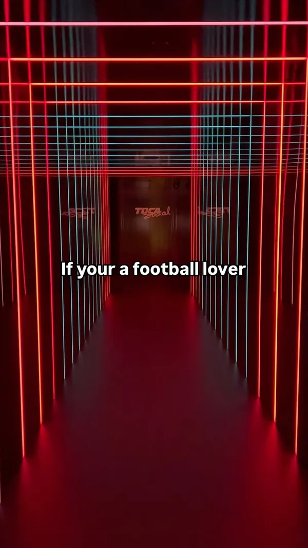 The video showcases TOCA Social, an interactive football and dining experience at the O2 in London.  It features two boys and their father playing interactive football games using projected technology. The venue's interior, which includes a bar area with tables and chairs, is also shown.  No specific food or drinks are prominently displayed.