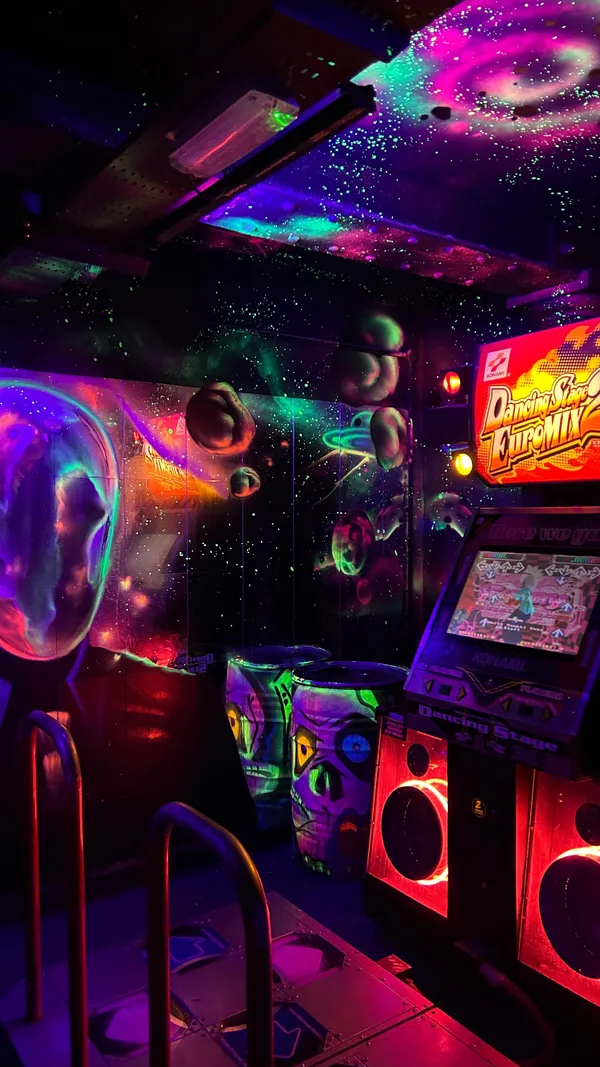 This video showcases NQ64, a bar in Glasgow that features a wide variety of arcade games and consoles. The video shows various games being played, including Mario Kart, The Simpsons Hit & Run, and others. The bar's cocktails are also highlighted. The primary focus is on the overall experience of the bar, with a positive and enthusiastic tone.