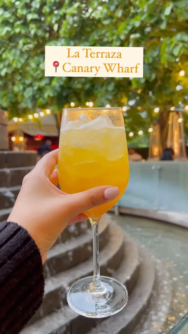 This video showcases La Terraza at Canary Wharf, promoting its ambiance, food, and drinks.  It opens with a shot of the outdoor terrace, then moves to show various food items (sandwiches, tortilla, sangria), and drink preparation. The video emphasizes the venue's relaxed and vibrant atmosphere.