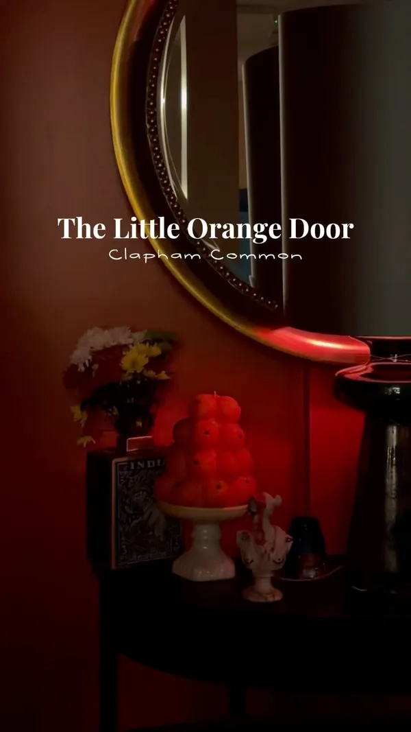 The video showcases The Little Orange Door, a bar in Clapham. It features various cocktails (Picante, Crimes of Passion, How to Lose a Guy in 10 Days), and bar snacks (wild mushroom and truffle arancini, mezze dips with taco chips, nduja, basil & truffle honey flatbread). The food and drinks are presented in a visually appealing manner, with a focus on close-up shots and overhead shots. The video doesn't explicitly mention dietary information, but it implies there may be vegetarian options based on the mezze and flatbread.