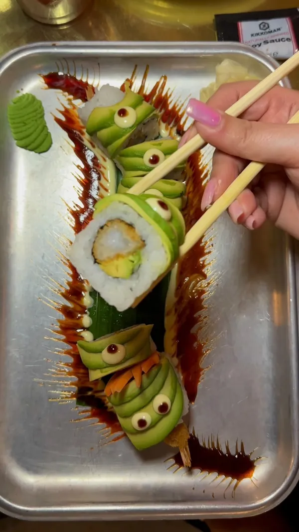 The video showcases a meal at Inamo Sukoshi, an Asian street food restaurant with multiple locations in London. It highlights several dishes: Korean BBQ ribs, a Dragon Roll (sushi), Asian-style steak and chips, and duck ramen. The food is presented attractively, with vibrant colors and visually appealing arrangements. The video's primary focus is on showcasing the variety and deliciousness of the food.