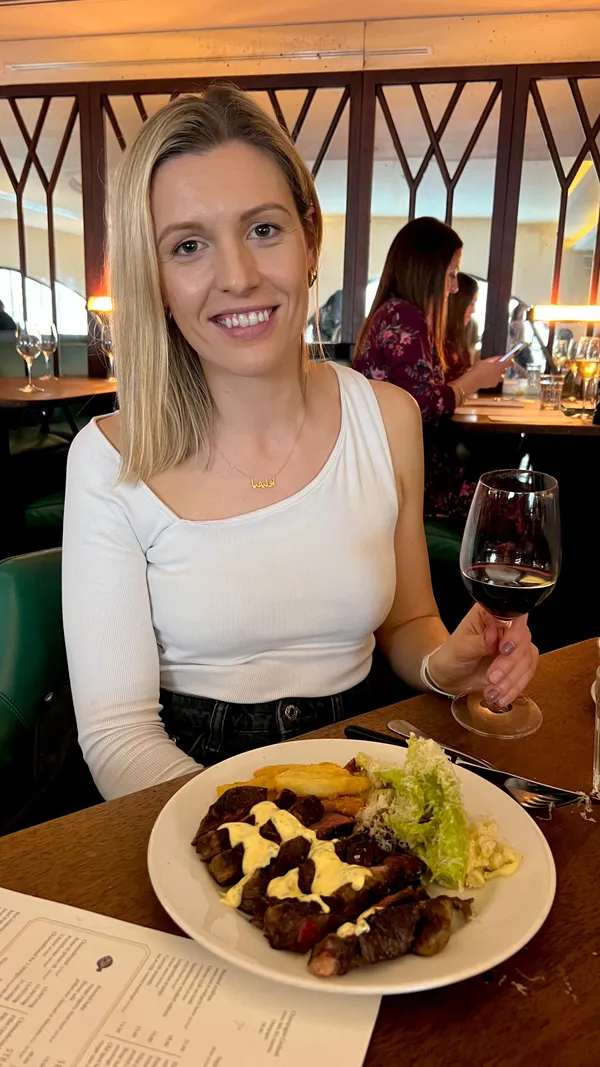 The video showcases a meal at Hawksmoor Air Street, a steak and seafood restaurant in London.  The video features buttery garlic scallops, crab on toast, sirloin and ribeye steaks served with Caesar salad, mac and cheese, chunky chips, béarnaise sauce, and bone marrow gravy. For dessert, rhubarb pavlova and sticky toffee pudding are shown. The setting is elegant and upscale.