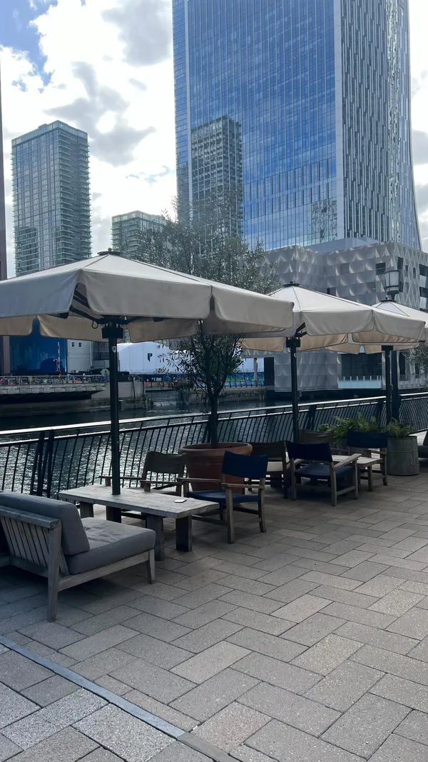This video showcases a meal at The Address restaurant in Canary Wharf, London. The video starts with shots of the restaurant's interior and then moves on to various food items, including chicken tenders, crispy squid, mini Cumberland sausages, a mixed roast, a steak, a burger, and mac and cheese. The food is presented in a visually appealing manner using small pans and dishes. The video also highlights the restaurant's bottomless brunch deal. The main focus is on showcasing the food and promoting the restaurant.