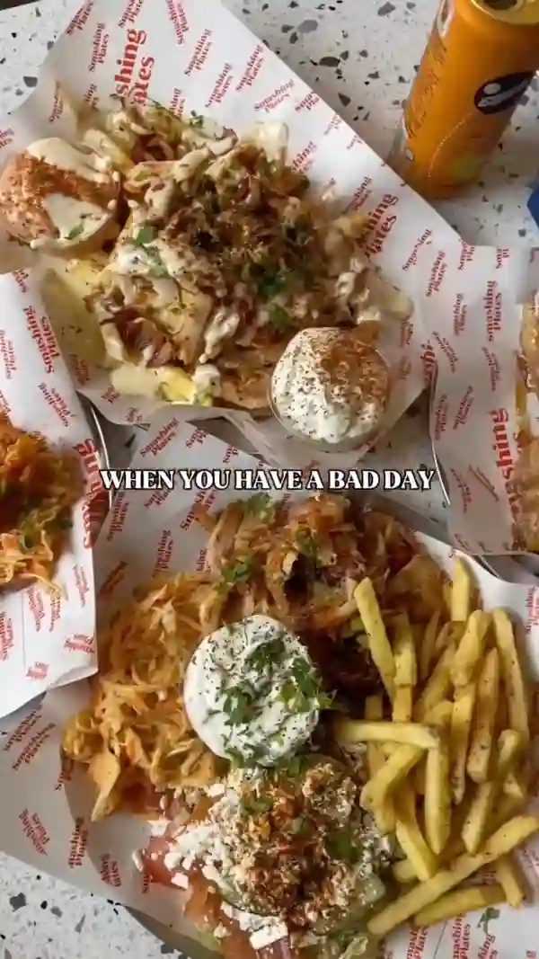 The video showcases a meal from Smashing Plates, a Greek eatery. It features various dishes, including gyros, souvlaki, halloumi fries, unorthodox fries, and baklava.  The food is presented on platters and individual plates. Dietary options are mentioned; vegan and gluten-free options are available. The primary focus is on a visually appealing presentation of the food and the overall dining experience.