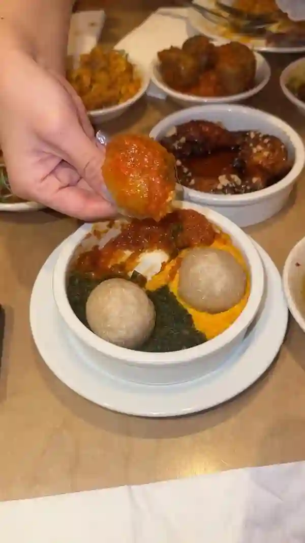 The video showcases a meal at Chuku's, a Nigerian tapas restaurant in London. It features various dishes, including honey prawns, lamb Ayamase, caramel Kuli Kuli wings, chicken ATA Din Din, suya meatballs, egusi bowl, jollof rice, and sweet okra.  Cocktails such as Chapman Punch and Chuku Bellinis Mango are also shown.  Desserts include Chin Chin Cheesecake and brownie. The food is presented in small, tapas-style bowls and plates. The video focuses on showcasing the food and the dining experience.