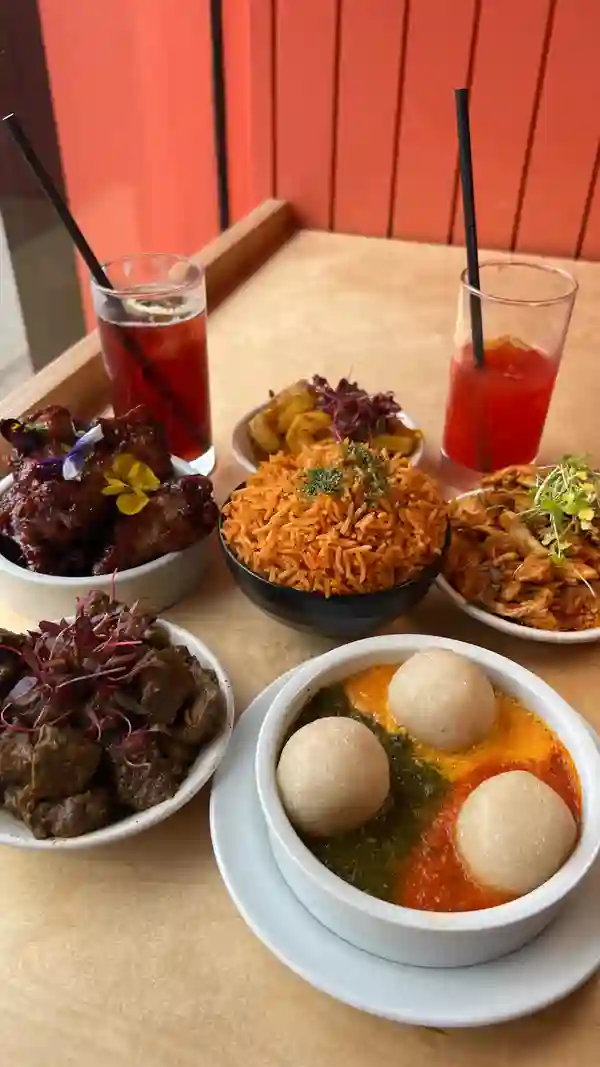 The video showcases Chuku's, a Nigerian tapas restaurant in London. It features various dishes, including Jollof Rice, Zoho chicken wings, Banga chicken, Banga prawns, Lamb Ayamese, and an Egusi bowl.  The drinks shown are The Eze and Chapman Punch. The food is presented in small, tapas-style portions, garnished with herbs and flowers.  Vegan, gluten-free, and Halal options are mentioned. The video primarily focuses on showcasing the food and ambiance of the restaurant.