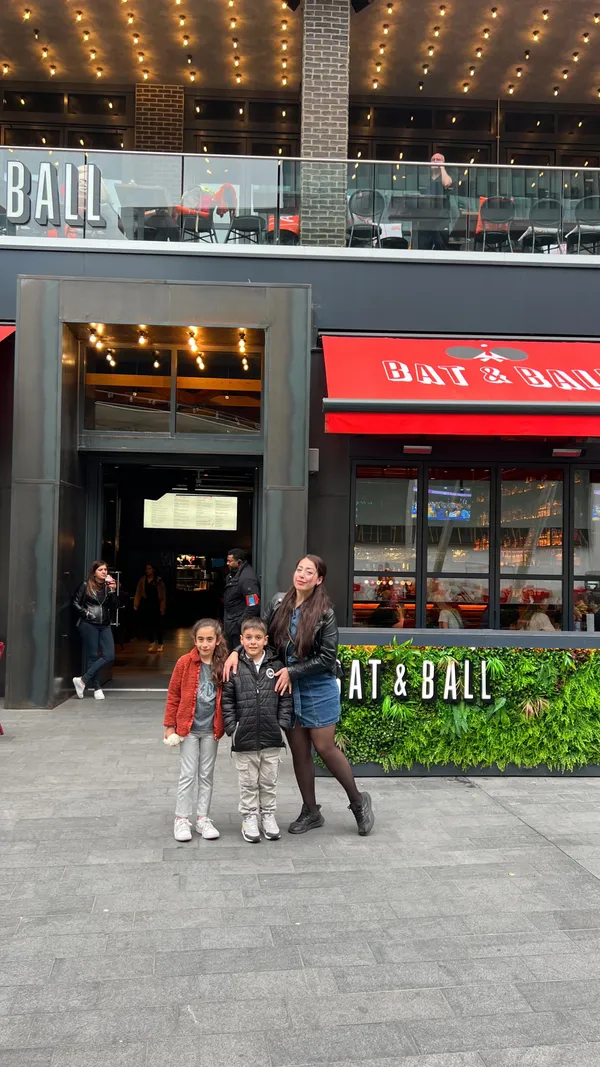 The video showcases Bat and Ball, a family-friendly entertainment venue in Westfield Stratford, London. It features various activities including karaoke, pool, and ping pong. The video highlights food and beverages served at the venue, including pizzas, and cocktails. The video is primarily focused on the venue's vibrant atmosphere and the entertainment it offers, targeting families and groups seeking fun activities.