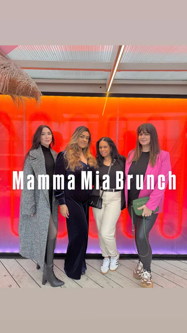 The video showcases a Mamma Mia-themed brunch event at Circe's Waterloo Rooftop bar. It features various shots of the venue, cocktails (orange-colored and yellow-colored drinks), and happy people enjoying the brunch, interspersed with shots of performers and bubble-blowing. The food itself is not prominently featured, but there are glimpses of brunch items and cocktails.