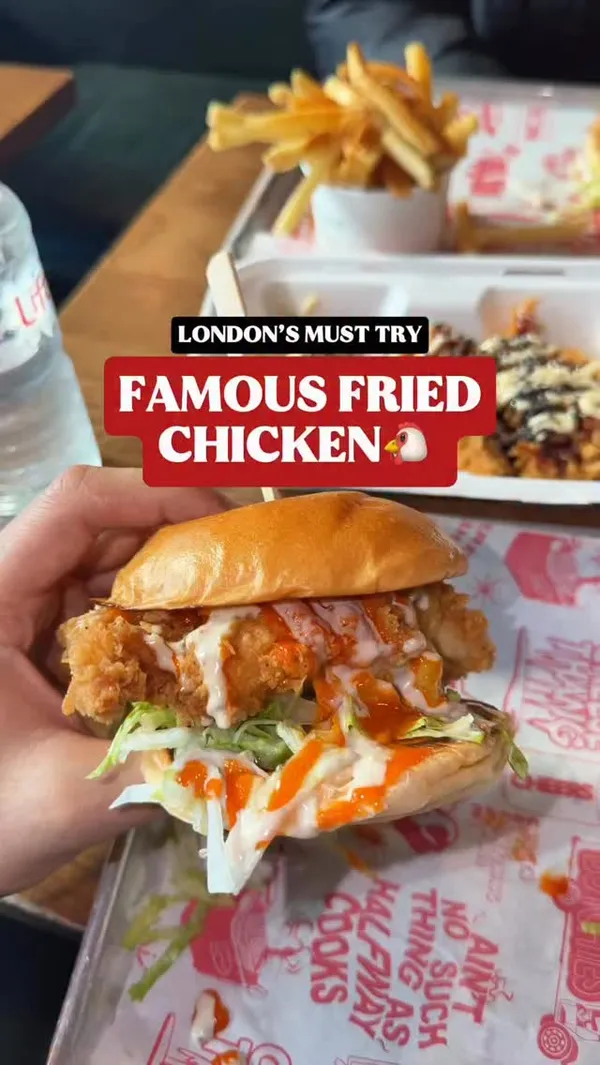 The video showcases a fried chicken restaurant named 'Butchies'. It begins with a shot of the restaurant's exterior, followed by close-ups of the food items, including a fried chicken burger with lettuce and sauces, french fries, and fried chicken tenders topped with mayonnaise, a dark sauce, and sesame seeds.