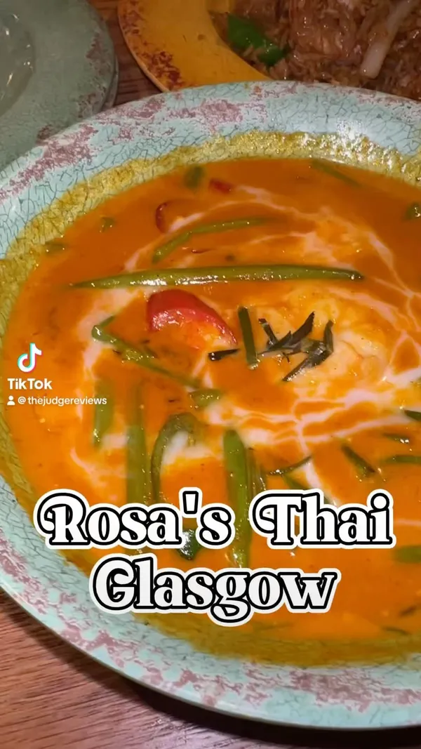 The video showcases a meal at Rosa's Thai restaurant in Glasgow. It features various dishes, including prawn doughnuts with a sugary syrup, a salad with heat, sticky fried rice with prawns, red prawn curry, and a tofu soup. The video emphasizes the taste and presentation of the food. Dietary information is limited, but halal options are mentioned in the caption.
