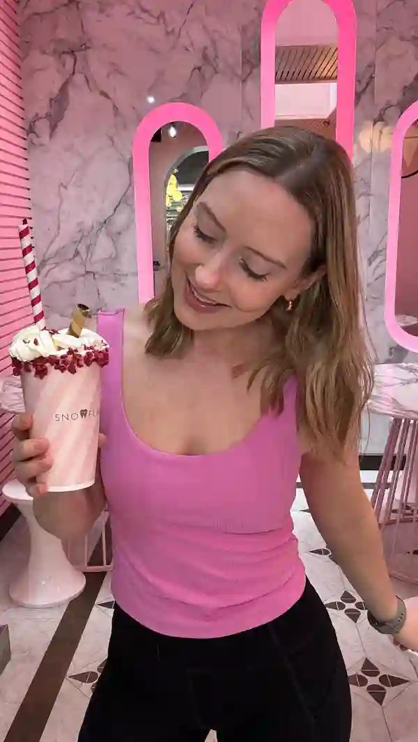 The video showcases Snowflake Gelato, a cafe in London, featuring their Wimbledon-themed summer menu. It highlights three items: a strawberry and meringue milkshake; a dessert featuring chocolate-covered strawberries and cookie crumbs; and a tennis ball-shaped dessert. The setting is the cafe itself, with a pink color scheme. The food presentation is visually appealing, with attention to detail and thematic elements. No dietary information is explicitly provided. The main focus is on showcasing the food and the cafe's atmosphere.