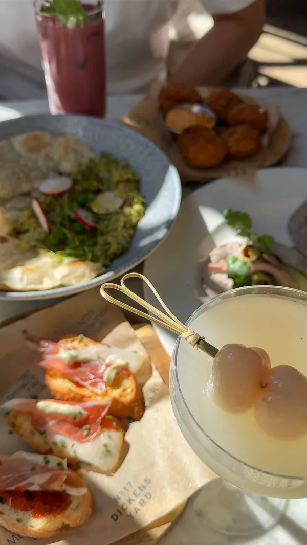 The video showcases a brunch at No 1a Duke Street in Richmond, London.  The food and drinks include a steak sandwich, sweetcorn and courgette hash with smoked salmon, brioche French toast, nduja and cheddar croquettes, garden pea and super green pesto hummus, and various cocktails. The presentation is visually appealing, with natural light enhancing the food's colors and textures.  The focus is on the delicious food and inviting atmosphere of the restaurant.