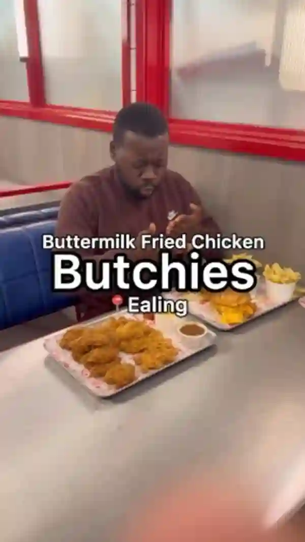 The video showcases a meal from Butchies, a buttermilk fried chicken restaurant in Ealing, London. The food includes chicken tenders, wings, mac and cheese, two burgers (BBQ and cheesy rider), and fries. The presentation focuses on close-ups of the food items and the overall meal spread. Dietary information is not explicitly provided. The main focus is on a food review, highlighting different items and the reviewer's opinions.