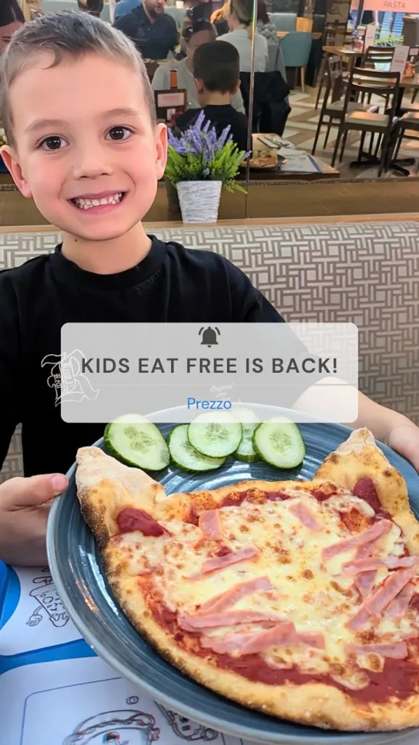 The video follows two young boys having a meal at a Prezzo Italian restaurant. It begins with them walking into the establishment. Inside, they are shown engaging with activity sheets and toys at their table. The video showcases various food items, including a baked mushroom appetizer with grilled bread, twisted bread with a dip, a kids' meal featuring mozzarella sticks and cucumber, and a pizza. Adult meals, including spaghetti bolognese and a creamy pasta dish topped with rocket, are also shown. The children are depicted enjoying their food and the overall experience in a modern, well-lit restaurant setting.