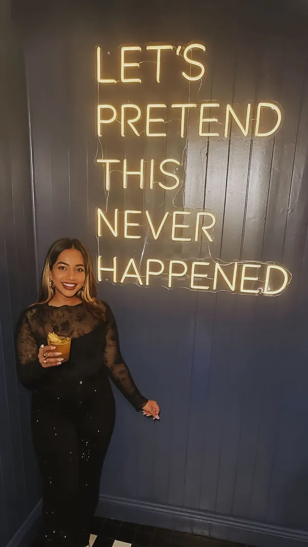 The video promotes a bar called Tequila Mockingbird in Putney. It starts with a shot of the entrance and a neon sign, then moves inside to show patrons playing electronic darts. The video features several close-up shots of various colorful cocktails, including an espresso martini and a passionfruit martini, as well as groups of people toasting. It also showcases two pizzas in detail: one with mushrooms and spinach, and another with pepperoni. The overall vibe is energetic and social, set to an upbeat music track.