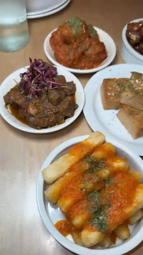 The video showcases a brunch experience at Chuku's in Seven Sisters. It features various Nigerian tapas dishes, including chicken wings in caramel sauce with peanuts, cassava fries with a spicy sauce, suya meatballs, a hearty egusi bowl with stew and peanut sauce, and moi moi.  The video also highlights drinks and desserts like a plantain waffle with ice cream and caramel. The primary focus is to show the food and drinks.