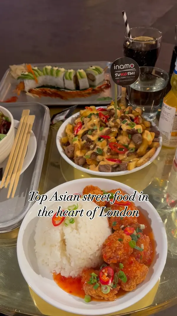 The video showcases a meal at Inamo Sukoshi, an Asian fusion street food restaurant in London's Market Halls. The food includes Karaage Chilli Chicken and Rice, Dirty Duck Fries, Pork Ramen, and a Dragon Roll (tempura shrimp and avocado). The presentation focuses on visually appealing arrangements and close-ups of the dishes.  No specific dietary information is provided.