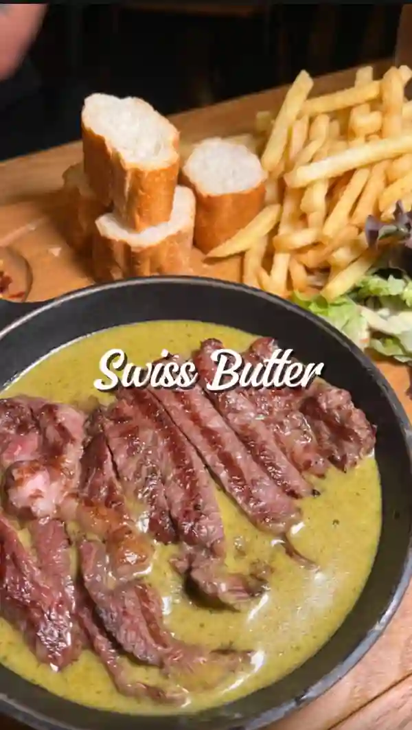 This video showcases Swiss Butter, a Halal steakhouse in London. The video highlights their £19 set menu, featuring ribeye beef, chicken, and salmon, all served with salad, baguette, and a choice of fries or baked potato.  The influencer also tries their Wagyu burger and two desserts: molten chocolate cake and a bread-pudding-French toast fusion. The video emphasizes the food's taste and presentation.