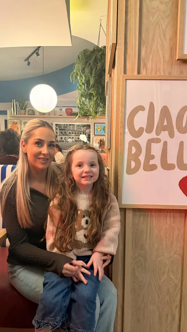 A video showcasing a dining experience at Prezzo Italian restaurant in Media City, Manchester. The video features shots of the restaurant's modern interior, including striped booths and art-decorated walls. It highlights various food and drink items, such as colorful cocktails, starters like meatballs and hummus with flatbread, and main courses including crab & lobster ravioli, lasagna, carbonara, garlic roast potatoes, and a Caesar salad. The video also emphasizes the family-friendly atmosphere by showing a young girl coloring and wearing 3D glasses. The experience concludes with a toast with limoncello shots and a final view of a neon sign reading 'PASTA PIZZA VINO'.