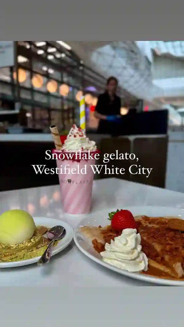 The video showcases Snowflake Gelato, a cafe in London. It features various gelato flavors (including pistachio and strawberry), gelato-based desserts (like a tennis ball-shaped dessert with a raspberry center), crepes with caramel sauce and Biscoff crumbs, and a strawberry milkshake. The presentation focuses on close-ups of the food items, emphasizing their colors and textures. Dietary information is not explicitly provided, but the caption mentions vegan and dairy-free options. The main focus is on a food showcase of different items at Snowflake Gelato.