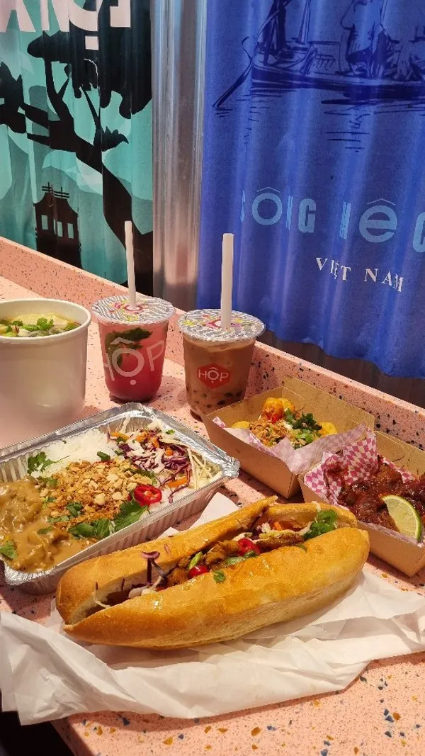 This video showcases Hop Vietnamese restaurant in Bond Street Station, London. It highlights various dishes including Banh Mi, Pho, and HOP boxes with sides like loaded tots.  The video emphasizes the ease of ordering and customization, caters to all dietary requirements, and mentions prices under \u00a310 per dish. The overall presentation is vibrant and focuses on the variety and quality of the food.