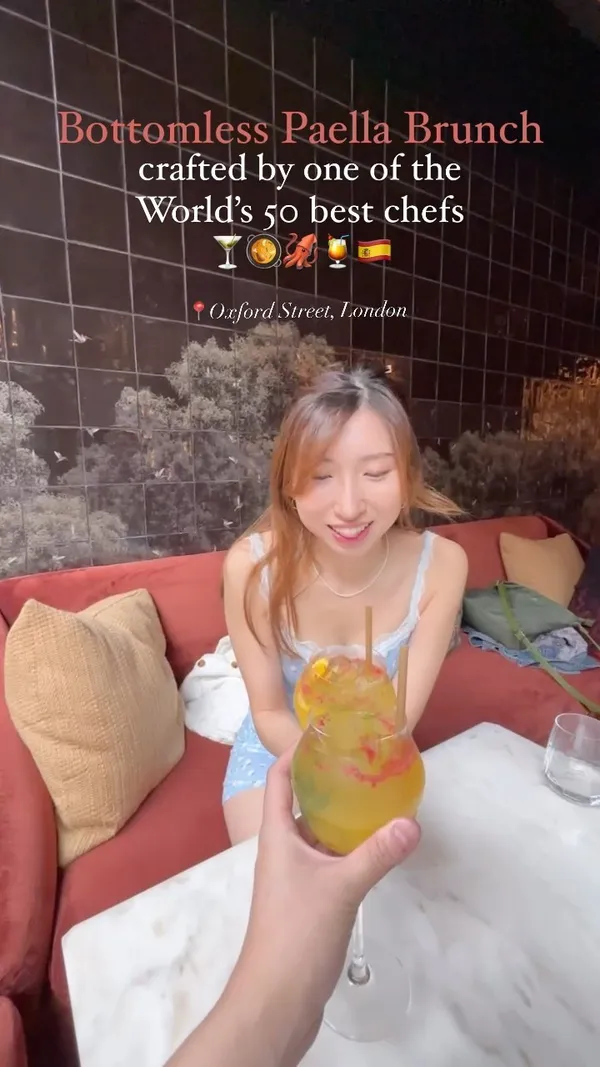 The video showcases a bottomless paella brunch at Arros QD in Fitzrovia, London.  It highlights various tapas dishes, including a truffle bomb, panipuri, and ceviche, alongside the paella itself (specifically, a black ink paella). Desserts like apple tart and Basque cheesecake are also shown. The video emphasizes the high-quality ingredients and stylish restaurant décor.