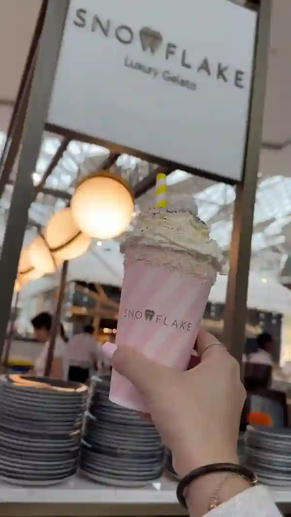 The video showcases a variety of food and beverages from Snowflake Luxury Gelato, a cafe located in Westfield London.  Items shown include waffles with pistachio sauce and strawberries, crepes with bananas and caramel sauce, a Snowflake Sundae Shake, and a selection of gelato and chocolate-covered treats. The presentation focuses on visually appealing close-ups and overhead shots of the food items, highlighting their colors and textures. No specific dietary information is provided.